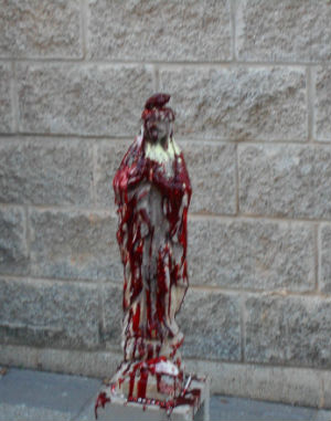 Satanists desecrate a statue of the Virgin Mary. Satanists desecrate a statue of the Virgin Mary.