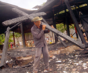 A man removes a charred cross from a burned out church. Christian persecution takes place constantly around the world. A man removes a charred cross from a burned out church. Christian persecution takes place constantly around the world.