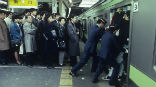 Image of Tokyo is so crowded that special workers cram people into the subway trains there.