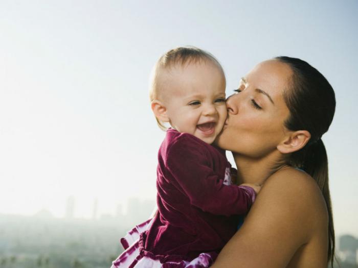 Woman kissing child. Woman kissing child.