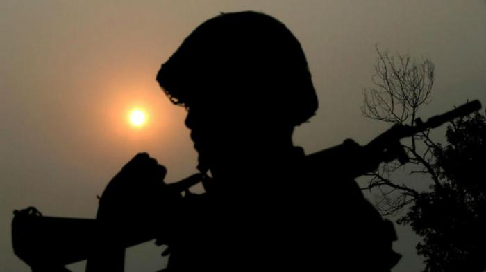 An Indian Border Security Force soldier is silhouetted against the sun as he patrols the border between India and Pakistan. An Indian Border Security Force soldier is silhouetted against the sun as he patrols the border between India and Pakistan.