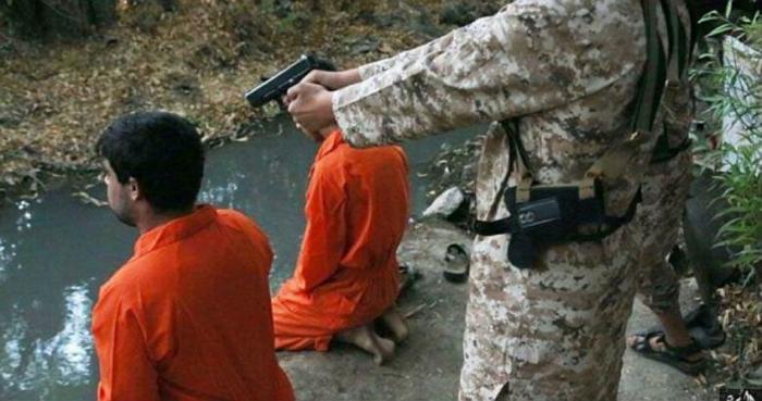 The alleged spies were forced to kneel so the young boys could shoot them. The alleged spies were forced to kneel so the young boys could shoot them.