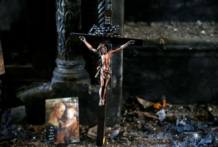 Christians celebrate Mass for the first time in two years within a burned and vandalized church.