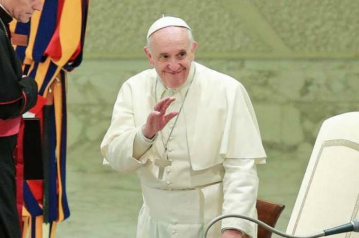 Pope Francis waves to pilgrims during.