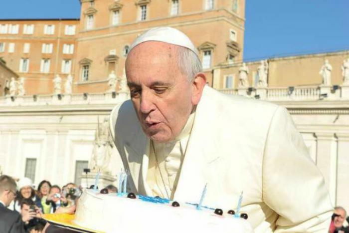 Pope Francis blows out candles on a cake for his 78th birthday.