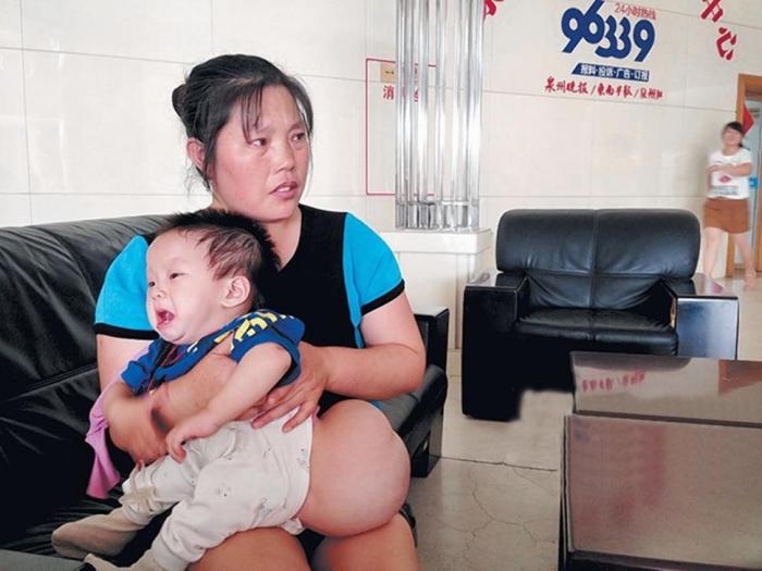This Chinese baby boy was born with a tumor at the base of his spine, which has now grown to the siz This Chinese baby boy was born with a tumor at the base of his spine, which has now grown to the siz