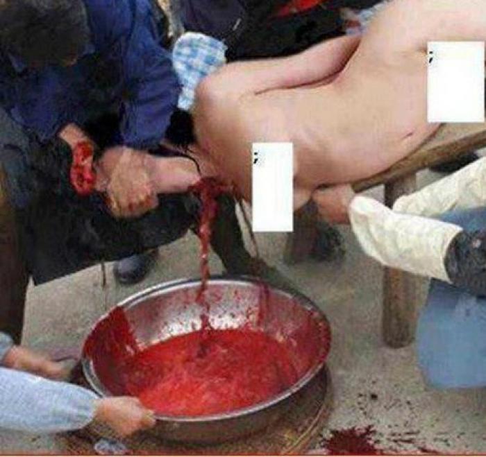 Islamists killing a woman by slitting her throat and capturing her blood in a bowl, holding her firm