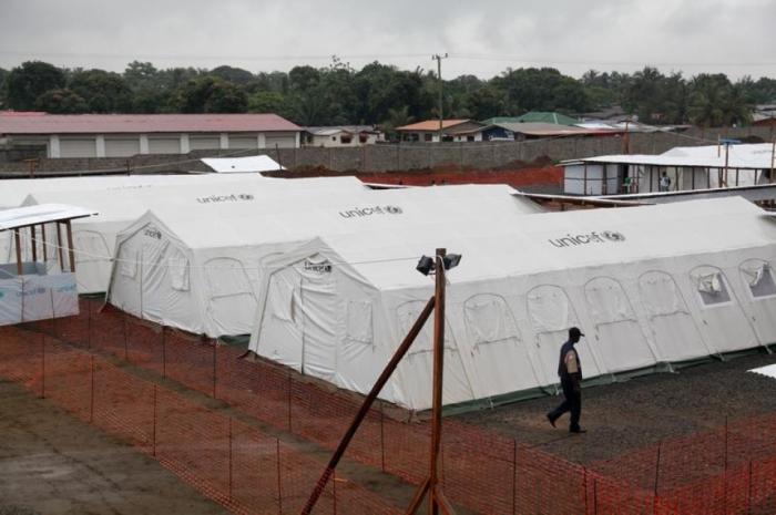 A worker walks past newly erected quarantine tents at the expanded ELWA Ebola Treatment Centre on th A worker walks past newly erected quarantine tents at the expanded ELWA Ebola Treatment Centre on th