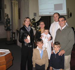 GODPARENTS PARTICIPATE IN BAPTISM VIA INTERNET – The godparents of baby Alban Roger Galiot Marie, held by his mother, Astrid Miorcec de Kerdanet, at his baptism ceremony in Devonport, New Zealand, in June, were able to participate in the child's baptism via Internet video conference from London. Pippa Turley, left, baptism proxy, and the child's father, Gael Miorcec de Kerdanet, are also shown with his sons, Aymeric and Gulihem, and Father Chris Brady, who baptized the baby and came up with the idea of the Internet hookup. (CNS/New Zealand Catholic) Image of GODPARENTS PARTICIPATE IN BAPTISM VIA INTERNET – The godparents of baby Alban Roger Galiot Marie, held by his mother, Astrid Miorcec de Kerdanet, at his baptism ceremony in Devonport, New Zealand, in June, were able to participate in the child's baptism via Internet video conference from London. Pippa Turley, left, baptism proxy, and the child's father, Gael Miorcec de Kerdanet, are also shown with his sons, Aymeric and Gulihem, and Father Chris Brady, who baptized the baby and came up with the idea of the Internet hookup. (CNS/New Zealand Catholic)