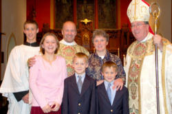 Fr. Dwight, his family and his Bishop. Image of Fr. Dwight, his family and his Bishop.