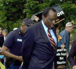 Dr. Keyes was one of the first arrested after one of the officers demanded they leave campus.The encounter became more intense when police began to remove Father Norman Weslin, a former Army Colonel who became a priest after his wife died in a tragic automobile accident. In his 80’s, Fr. Weslin is a familiar figure in the work of Pro-Life through Lambs of Christ. Image of Dr. Keyes was one of the first arrested after one of the officers demanded they leave campus.The encounter became more intense when police began to remove Father Norman Weslin, a former Army Colonel who became a priest after his wife died in a tragic automobile accident. In his 80’s, Fr. Weslin is a familiar figure in the work of Pro-Life through Lambs of Christ.