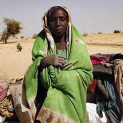 A newly arrived refugee from the Darfur region of Sudan rests next to her belongings in Seneit, Birak area, eastern Chad. Image of A newly arrived refugee from the Darfur region of Sudan rests next to her belongings in Seneit, Birak area, eastern Chad.