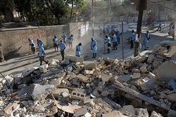 Haitian workers sweep the streets in front of a house that was destroyed by a major earthquake that struck Haiti killing over 200,000 and leaving over a million people homeless. The WHO stopped providing free drugs to private clinics and NGOs in Haiti after reports patients were being charged, potentially dealing a big blow to the already stumbling aid effort. Image of Haitian workers sweep the streets in front of a house that was destroyed by a major earthquake that struck Haiti killing over 200,000 and leaving over a million people homeless. The WHO stopped providing free drugs to private clinics and NGOs in Haiti after reports patients were being charged, potentially dealing a big blow to the already stumbling aid effort.