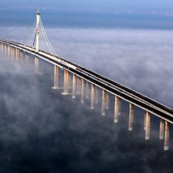 Qingdao Jiaozhou Bay Bridge has eight lanes and connects two districts. The journey between the two regions is now shorter by nineteen miles and by half the original travel time of forty minutes. It took $2.3 billion and four years to build. Qingdao Jiaozhou Bay Bridge has eight lanes and connects two districts. The journey between the two regions is now shorter by nineteen miles and by half the original travel time of forty minutes. It took $2.3 billion and four years to build.