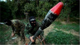 A member of the Popular Resistance Committees in Palestine prepares to launch a rocket into Israel. Image of A member of the Popular Resistance Committees in Palestine prepares to launch a rocket into Israel.