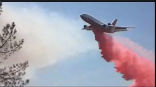 This amateur photograph shows a DC-10 tanker dropping retardant on one of the Texas wildfires. Image of This amateur photograph shows a DC-10 tanker dropping retardant on one of the Texas wildfires.