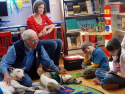 Don Smith and his dog Brasil listen to a young girl read at East Norwalk Library in Conn. The dogs and children participate in the library's Image of Don Smith and his dog Brasil listen to a young girl read at East Norwalk Library in Conn. The dogs and children participate in the library's