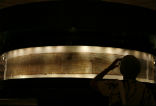 A visitor views the original scrolls on display. Image of A visitor views the original scrolls on display.