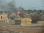 A village is set alight during last week's fighting. Image of A village is set alight during last week's fighting.