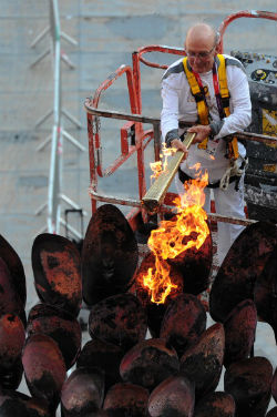 Senior-citizen athlete and veteran Olympian Austin Playfoot reignites the Olympic flame. Senior-citizen athlete and veteran Olympian Austin Playfoot reignites the Olympic flame.