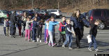 Children with their eyes closed being escorted from their classrooms. Image of Children with their eyes closed being escorted from their classrooms.