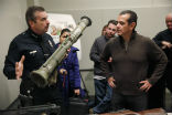 Police Chief Charlie Beck with one of the rocket launchers collected during the buyback. Image of Police Chief Charlie Beck with one of the rocket launchers collected during the buyback.