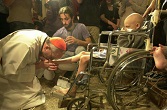 Pope Francis as a Bishop washing the feet of a young, disabled man Image of Pope Francis as a Bishop washing the feet of a young, disabled man