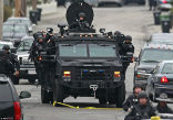 A Swat team sweeps the Watertown area in the hunt for suspect No. 2. Image of A Swat team sweeps the Watertown area in the hunt for suspect No. 2.