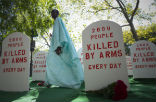 An activist walks amongst a display designed to raise awareness about arms trafficking. Image of An activist walks amongst a display designed to raise awareness about arms trafficking.
