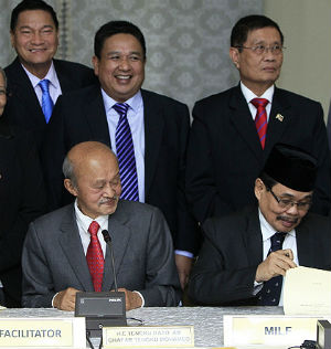 Government representative Miriam Coronel-Ferrer (front left) and the rebel's Mohagher Iqbal (front right) signed peace agreements this past weekend. Government representative Miriam Coronel-Ferrer (front left) and the rebel's Mohagher Iqbal (front right) signed peace agreements this past weekend.