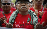 A Muslim wearing a shirt in support of the ban on non-Muslim use of the Arabic word for God. Image of A Muslim wearing a shirt in support of the ban on non-Muslim use of the Arabic word for God.