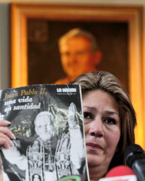 Floribeth Mora Diaz holds up the magazine that laid beside her on her death bed when she prayed to Pope John Paul for a miracle to cure her brain aneurism. Floribeth Mora Diaz holds up the magazine that laid beside her on her death bed when she prayed to Pope John Paul for a miracle to cure her brain aneurism.