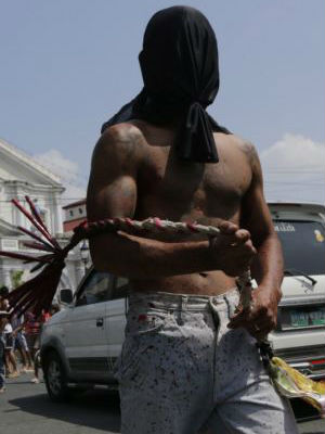 The penitents in San Fernando whip their backs as they make their way along narrow roads which lead to a dusty hill. The penitents in San Fernando whip their backs as they make their way along narrow roads which lead to a dusty hill.