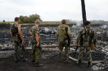 Russian backed separatists stand around wreckage from the downed Malaysian Airlines plane. Image of Russian backed separatists stand around wreckage from the downed Malaysian Airlines plane.