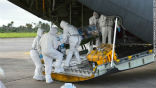 Medics load an infected Ebola patient onto a plane for medical transport. Image of Medics load an infected Ebola patient onto a plane for medical transport.