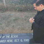 Fr. Pavone prays at the graveside of the children Image of Fr. Pavone prays at the graveside of the children