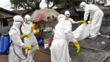 Health workers transport the body of an Ebola victim wrapped in a plastic bag. Ebola victims are burned in the bags they're collected in. Image of Health workers transport the body of an Ebola victim wrapped in a plastic bag. Ebola victims are burned in the bags they're collected in.