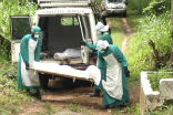 Aid workers in protective gear pick up the bodies of those killed by Ebola in Sierra Leone. Image of Aid workers in protective gear pick up the bodies of those killed by Ebola in Sierra Leone.