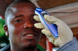 A Liberian man is having his temperature taken by a no-contact thermometer. Image of A Liberian man is having his temperature taken by a no-contact thermometer.
