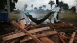 Aid workers in protective suits dispose of the bodies of Ebola victims. Image of Aid workers in protective suits dispose of the bodies of Ebola victims.