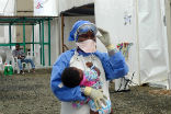 An aid worker carries a child infected with Ebola in Liberia, one of the West African nations hardest hit by the outbreak. Image of An aid worker carries a child infected with Ebola in Liberia, one of the West African nations hardest hit by the outbreak.