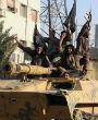 Members of the Islamic State ride a captured tank through an Iraqi city displaying their black flags. Image of Members of the Islamic State ride a captured tank through an Iraqi city displaying their black flags.