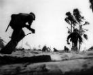 U.S. Marines advance while under fire from Japanese defensive positions. Image of U.S. Marines advance while under fire from Japanese defensive positions.