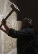 An ISIS member destroys part of an ancient wall in Syria. Image of An ISIS member destroys part of an ancient wall in Syria.