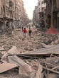 Two people walk through what is left of a Syrian neighborhood. Image of Two people walk through what is left of a Syrian neighborhood.