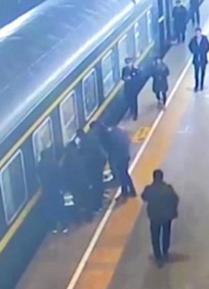 Passengers rally together to pull the child from the tracks (CGTN/YouTube). Passengers rally together to pull the child from the tracks (CGTN/YouTube).