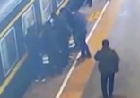 Passengers rally together to pull the child from the tracks (CGTN/YouTube). Image of Passengers rally together to pull the child from the tracks (CGTN/YouTube).