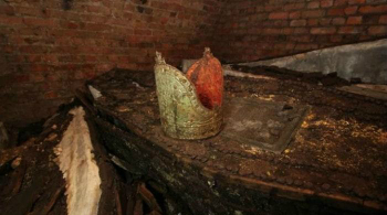 A gold mitre rested atop one of the lead coffins in the crypt. How did it get there? A gold mitre rested atop one of the lead coffins in the crypt. How did it get there?