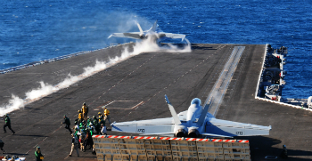 F-18 jets fly from the deck of the USS Carl Vinson. F-18 jets fly from the deck of the USS Carl Vinson.