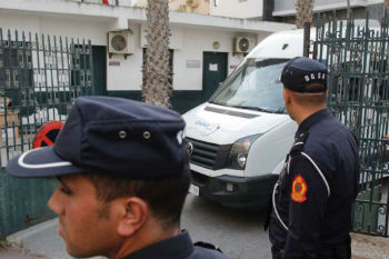 Moroccan security forces stand guard as a van leaves the court Moroccan security forces stand guard as a van leaves the court